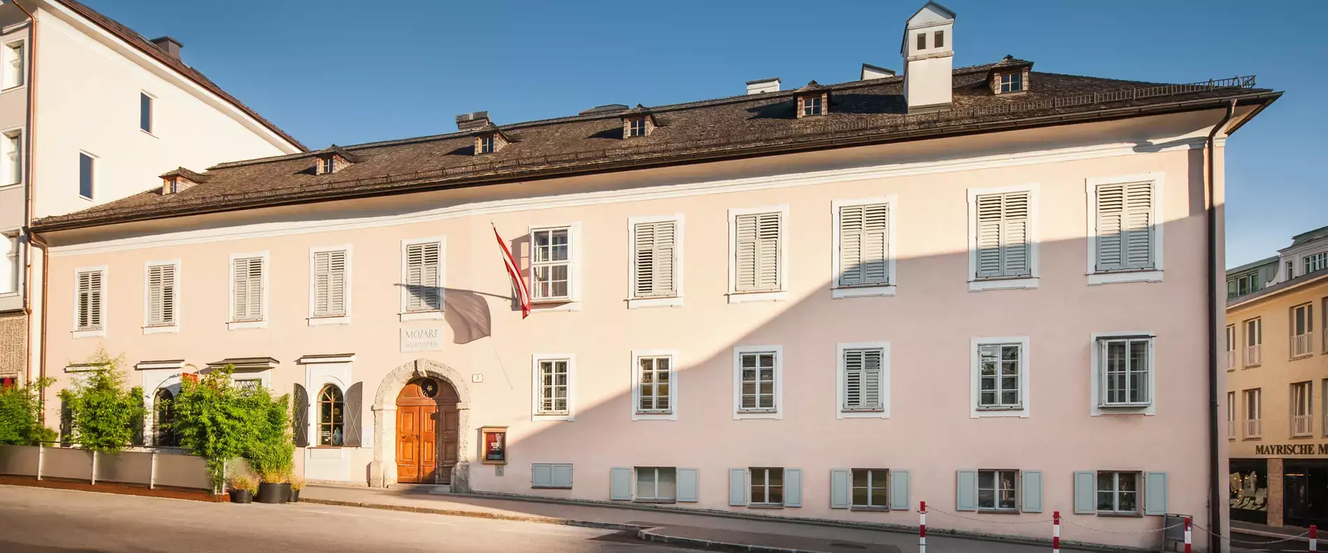 Außenansicht von Mozarts Wohnhaus in Salzburg mit gelber Fassade und historischer Architektur.