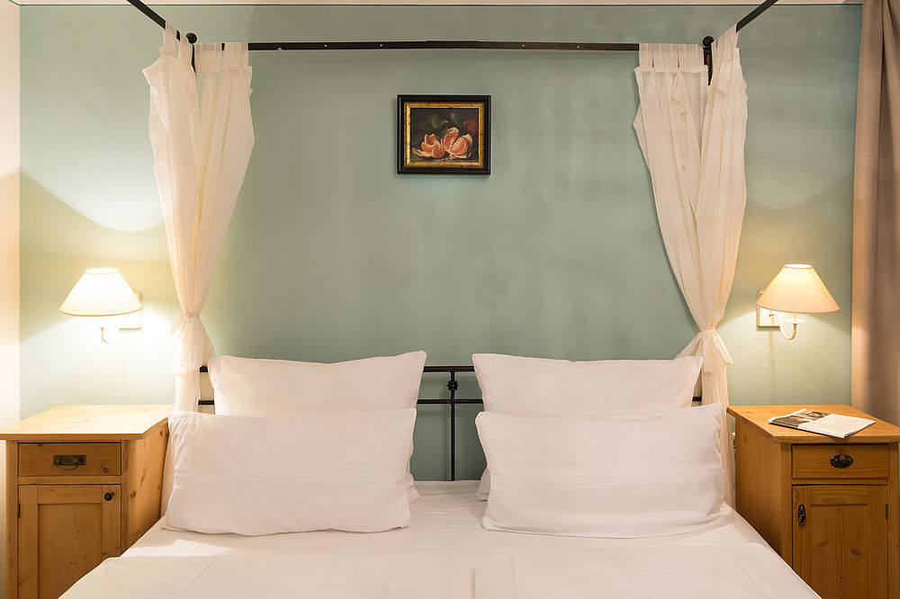 Stilvolles Doppelzimmer mit frisch gemachtem Bett im Familienhotel in Salzburg 