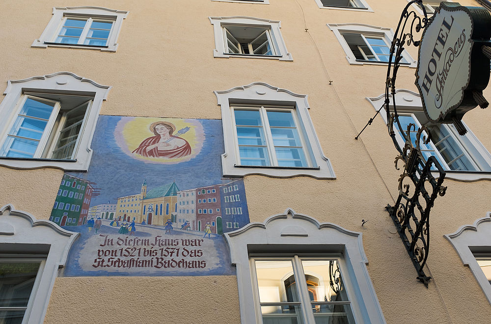 Hausfassade des Hotel Amadeus mit antiken Fenstern und Gemälden in Salzburg 