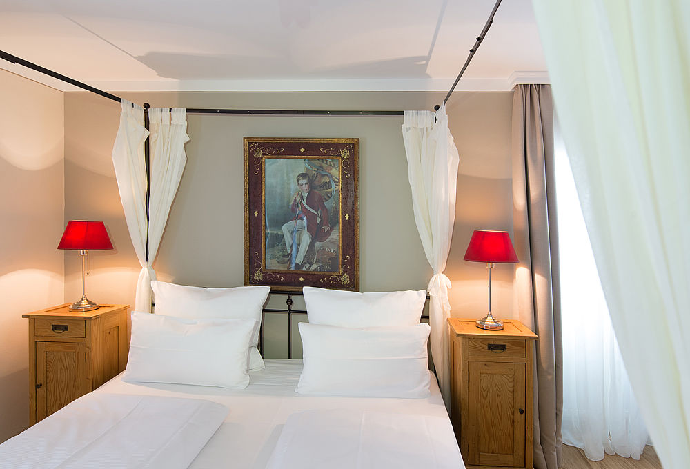 Gemütliches Doppelzimmer mit Bett, Bild und Tischlampen im Hotel Amadeus in der Stadt Salzburg