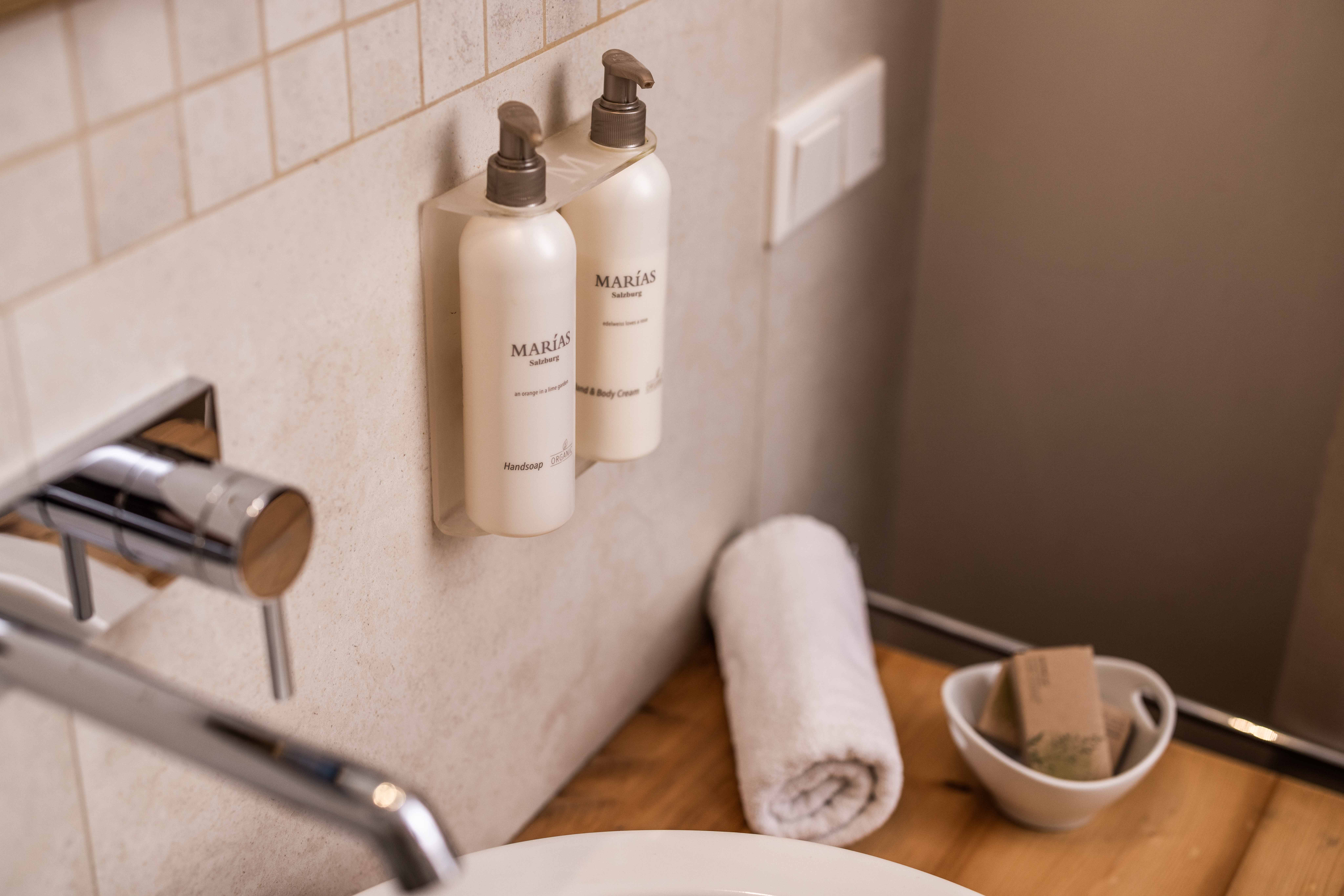Soap dispenser of high-quality organic cosmetics by Maria Pieper on the wall bracket in the bathroom