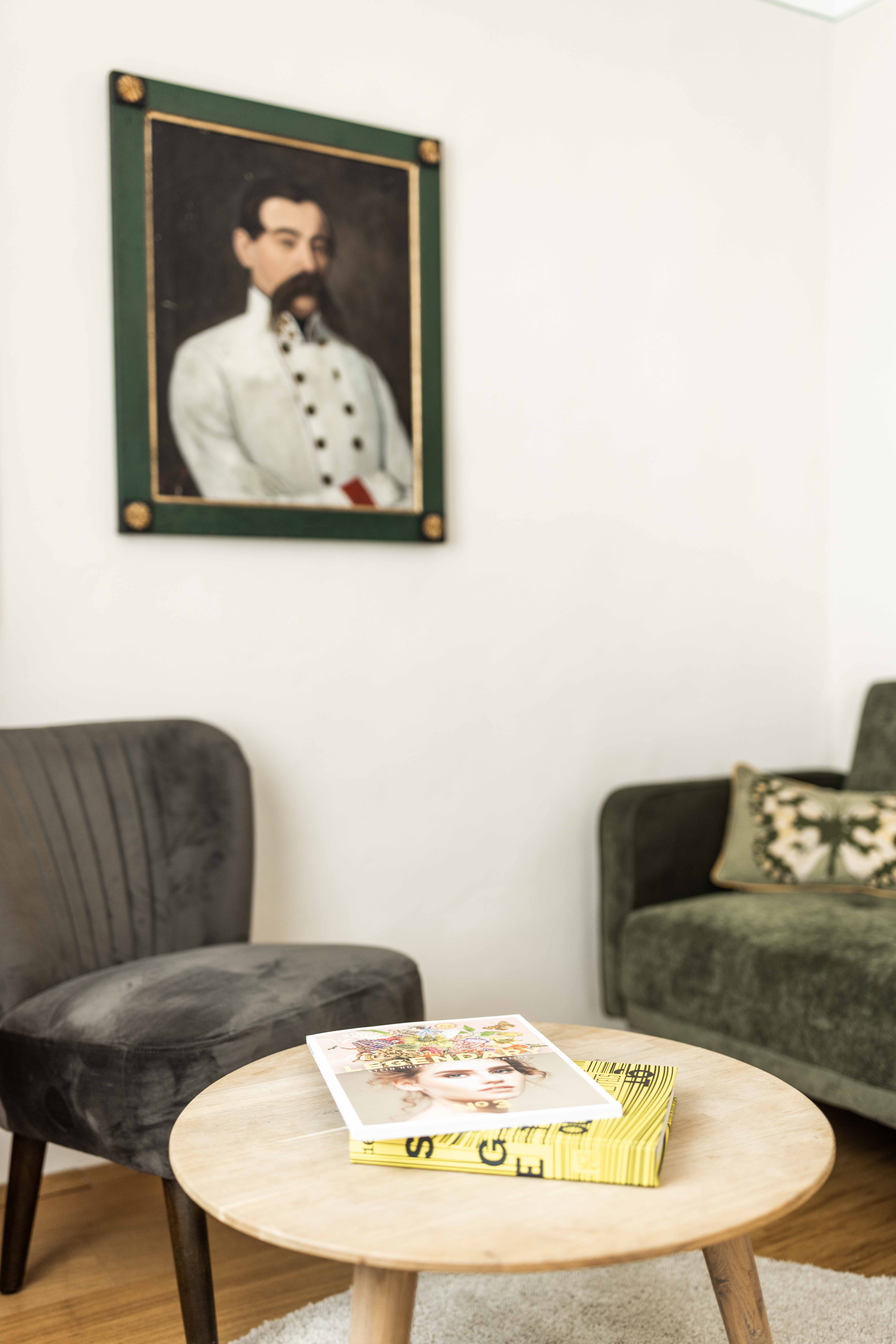 Reading corner with elegant vintage style furniture and a portrait of an officer on the wall